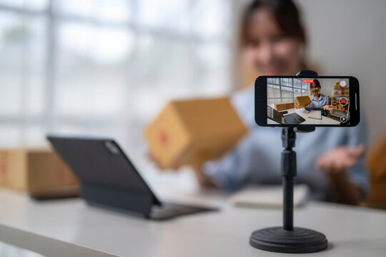Online seller recording product review video using smartphone on tripod