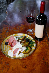 Pork fillet with potatoes and sauce wwith a bottle and a glass of wine
