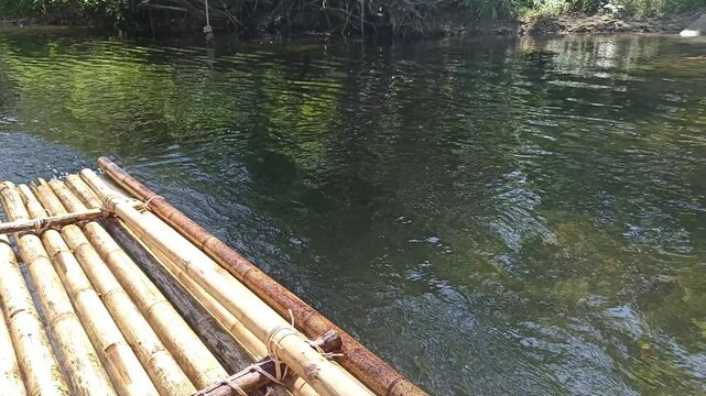 traveling sailing bamboo raft on river in tropical forest jungle