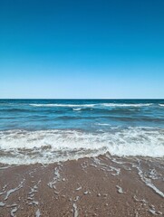 Beach scene with gentle waves and a blue sky, capturing the essence of tranquility. Valencia, Spain.