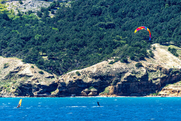 Windsurfing and paragliding in the bay by the beach in Baska on the island of KRK,