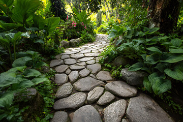 Natural stone path weaving through a lush garden, highlighting the beauty of textures and greenery.