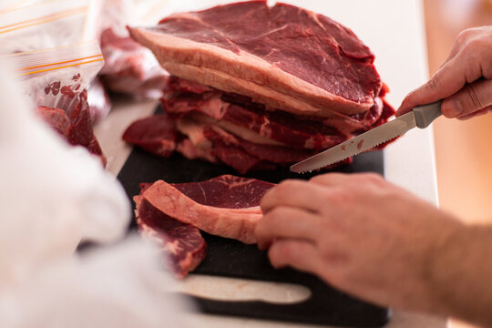 preparing steaks ready to freeze in portions with knife