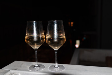 Two glasses of wine on the balcony ledge of a hotel in the summer evening, at night. Vacation time.