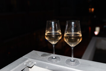 Two glasses of wine on the balcony ledge of a hotel in the summer evening, at night. Vacation time.
