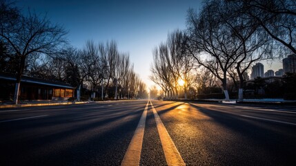 Empty city road at sunrise with silhouettes of trees and a clear sky