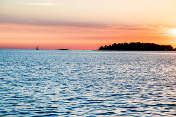 Incredibly beautiful romantic landscape with with a sailboat at sunset at sea between the islands (vacation, rest, harmony, meditation, honeymoon - concept)