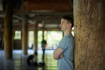 Portrait of male traveler leaning against pillar