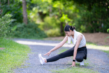 A woman is stretching her leg on a path
