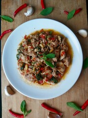 Pad Krapow, a signature Thai stir-fry dish made with fragrant chili and holy basil, is served on a...