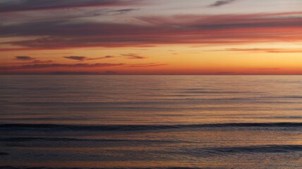 Fototapeta premium Serene sunset over tranquil ocean waves and vibrant sky