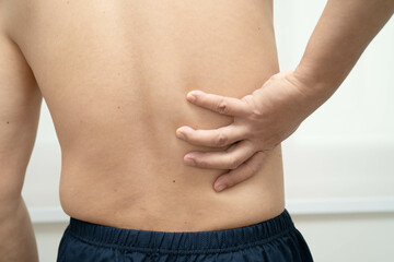 Asian man pain back muscle, spine and bone from accident.