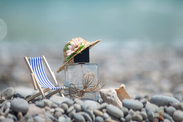 perfume bottle in a hat next to a sun lounger, sun umbrella, shells on the sand