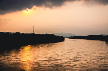 A river with a pole in the water. The pole is in the water and is not visible