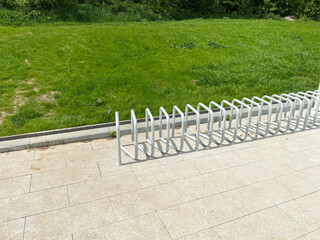 Bicycle parking or Bike rack in the city park. Modern curved metal construction design.
