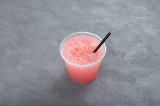 Pink Slushie - drink with natural grapefruit juice. Sweet shaved ice or Spanish granizado in disposable plastic cup. Refreshing summer drink.  Street food take away