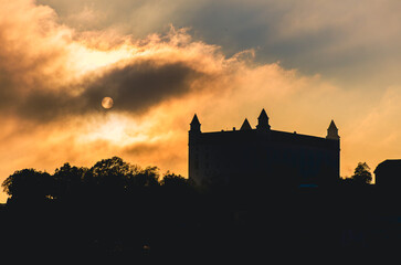 Obraz premium Bratislava evening. A castle is silhouetted against a cloudy sky. The castle is on a hill