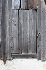 Old wooden window with closed shutters on the facade of the house