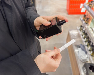 Man buying make up at cosmetics section in store. choosing cosmetics, perfumes, creams and shampoos, Using tester.

