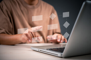 person working on a laptop with digital flowchart graphics, focusing on creating a business process...