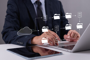 Professional managing digital documents and data flow on laptop, symbolizing cloud computing,...