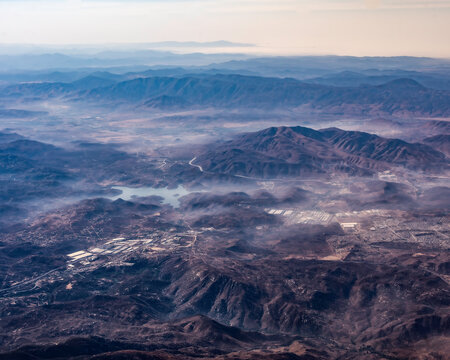mountains in the morning fog, aerial view from airplane window