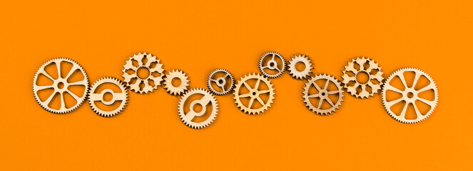 Wooden cogwheels on orange background