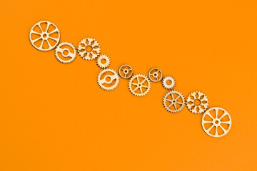 Wooden cogwheels on orange background