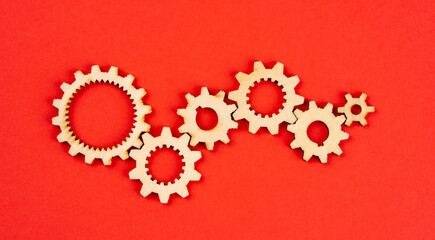Wooden cogwheels on red background