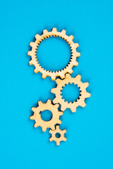 Wooden cogwheels on blue background 