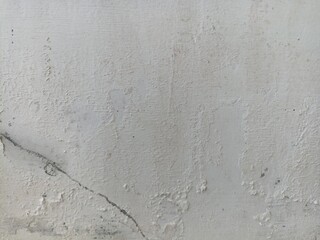 Cracked and Textured White Wall Surface. Close-up of a white plaster wall with cracks, peeling...