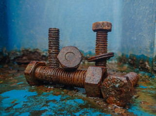 Rusty bolts and nuts on blue surface