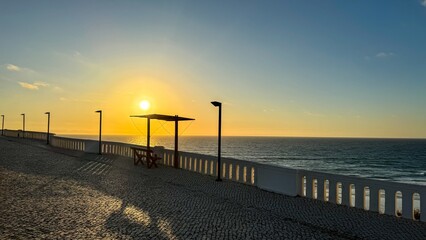 Sunset promenade whispers on Atlantics cobblestone edge, embracing equinox reflections, maritime...