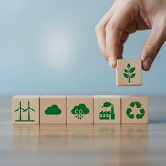 Hand placing a wooden block with a green plant symbol on eco friendly icons