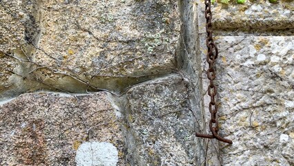 Rusty chain clings to ancient stone wall, whispering eerie tales of forgotten Beltane rituals and...