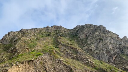 Rugged mountain peak under cerulean sky, reminiscent of Earth Day's verdant renewal and the ancient...