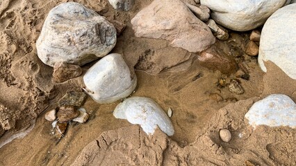 Weathered stones cradle whispers of ancient tides, evoking Earth Day's symphony and geologist's appreciation week, amidst sandy solitude
