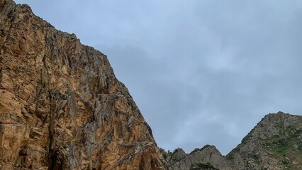 Rugged cliffs ascend majestically under a brooding sky, hinting at ancient tales of Earth Day and Fengari's Night