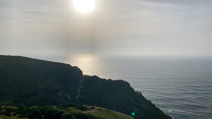 Sunset whispers over rugged cliffs, invoking ancient coastal myths and solstice celebrations, nature's serene masterpiece draped in silver hues