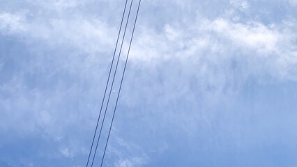 Electric lines cutting serene azure sky, whispering Festa della Repubblica dreams; kinetic energy meets tranquil cloud ballet