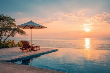 Poolside scene with chair umbrella  sunset view over ocean