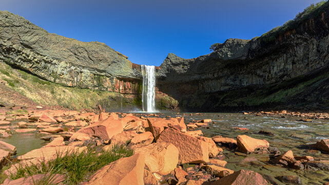Salto del Agrio plunges over a rocky cliff face into a pool. Neuquen, Argentina