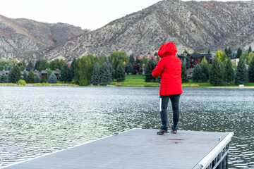 Nottingham lake park dock in Avon, Colorado cold morning with woman on fishing pier at sunrise in small mountain village ski town city