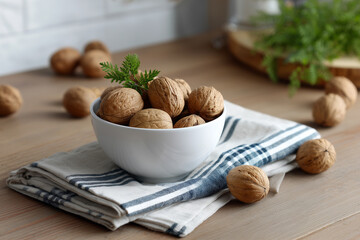 Walnuts arranged in a bowl on a wooden table with cloth