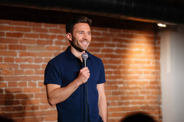 Stand-up comedian performs at a cozy brick wall venue