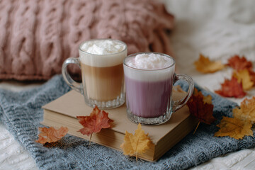 Cozy autumn drinks on a warm blanket with colorful leaves