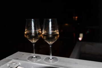 Two glasses of wine on the balcony ledge of a hotel in the summer evening, at night. Vacation time.