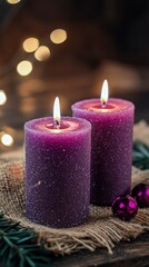Two Purple Candles Burning Brightly on Rustic Burlap with Festive Lights and Ornaments