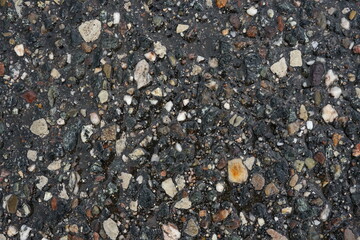 Wet asphalt texture with colorful gravel and stones