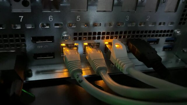 A close-up video of blinking LED lights at RJ-45 connector ports on active network servers, creating a futuristic symphony of rhythmic pulses. 